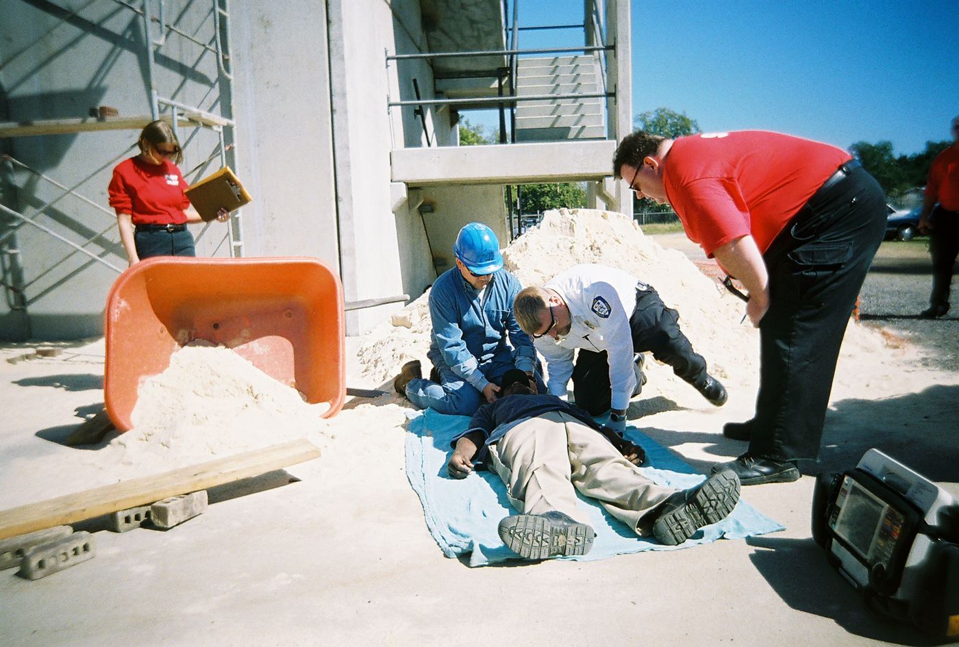 Judges watching a team work a scenario beside a pile of sand in Sumter, 2006