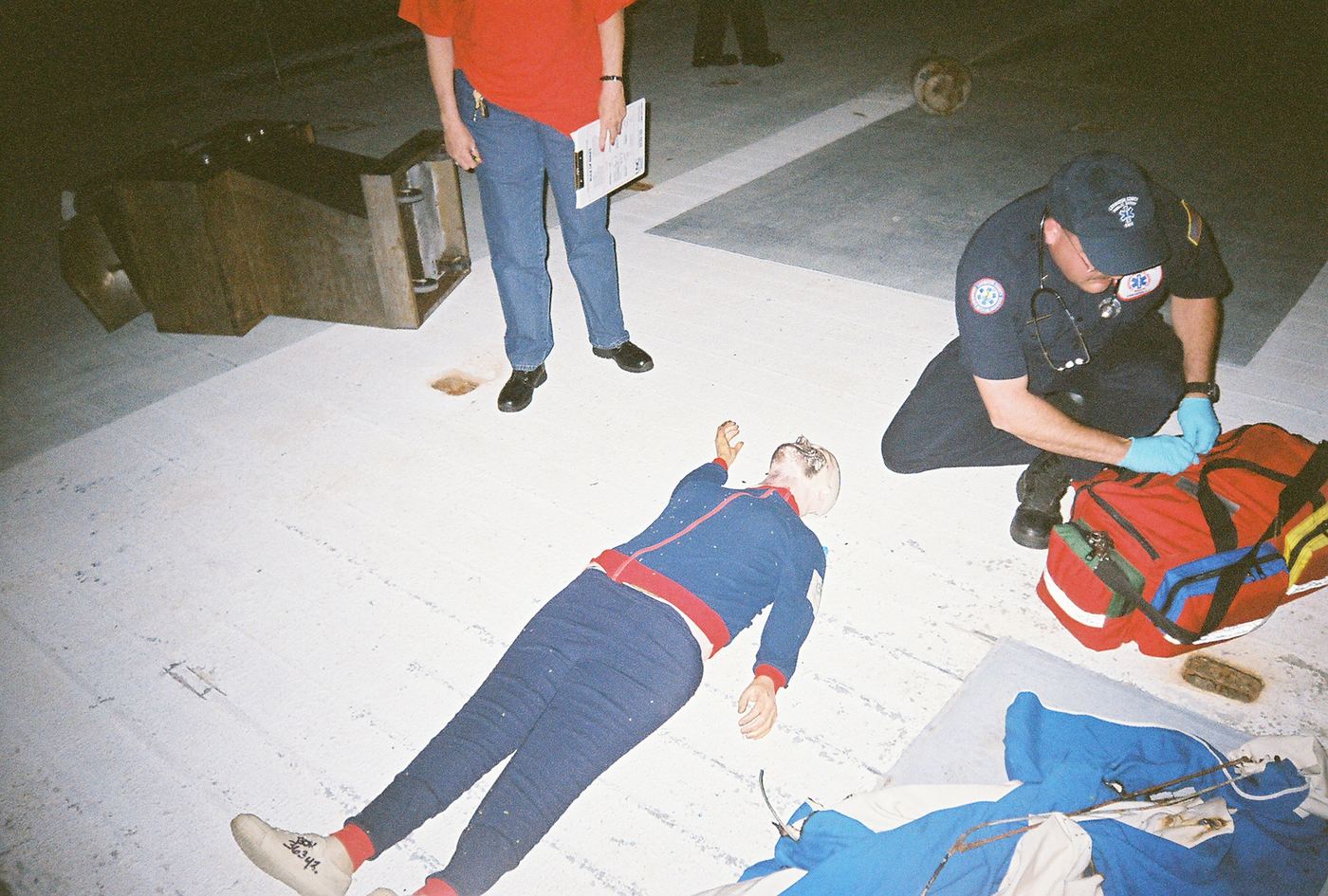 A medic opening a bag beside a patient during a night scenario in Charleston, 2008