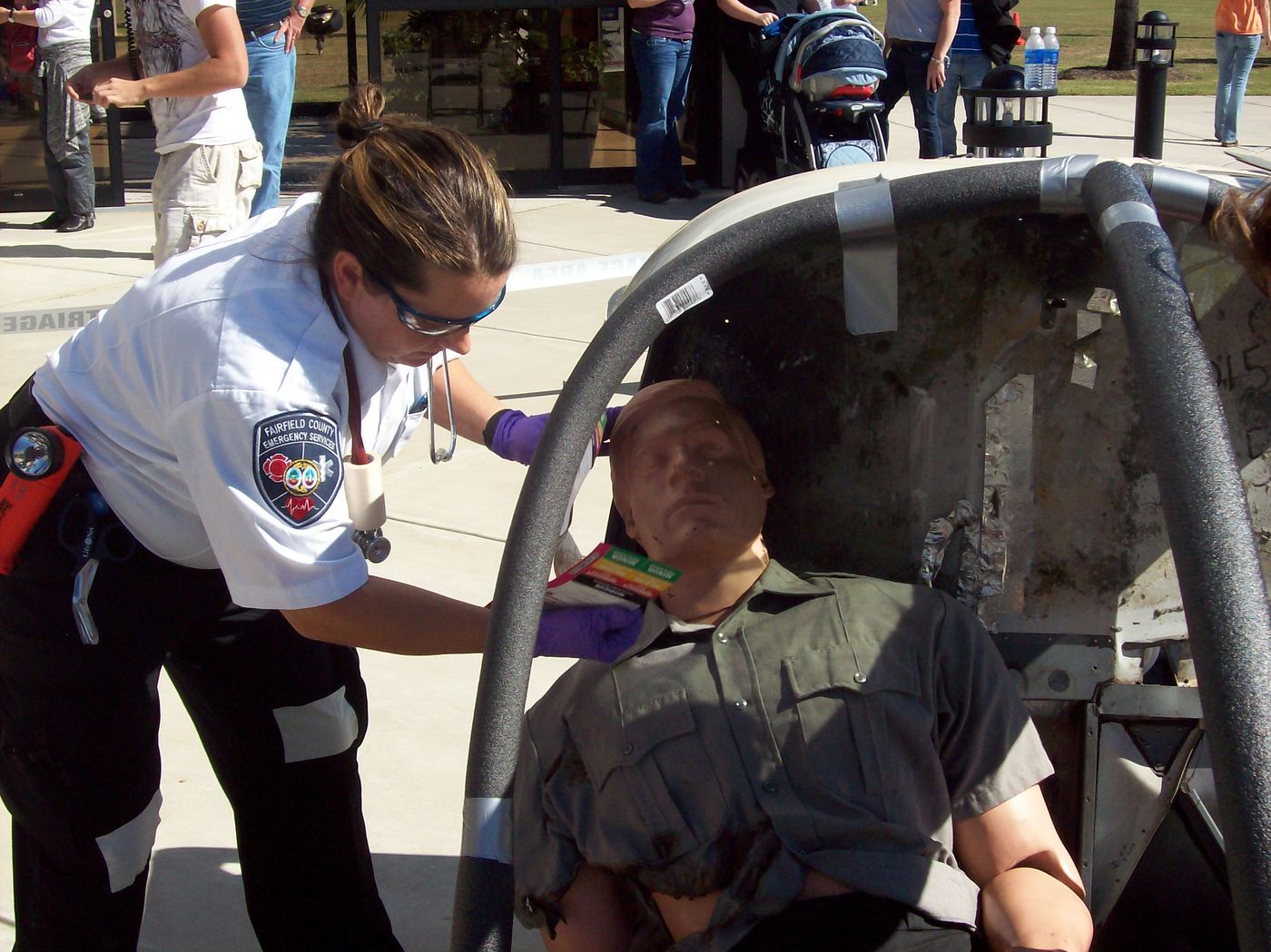 A medic treating a patient seated in a wrecked vehicle in Florence, 2010